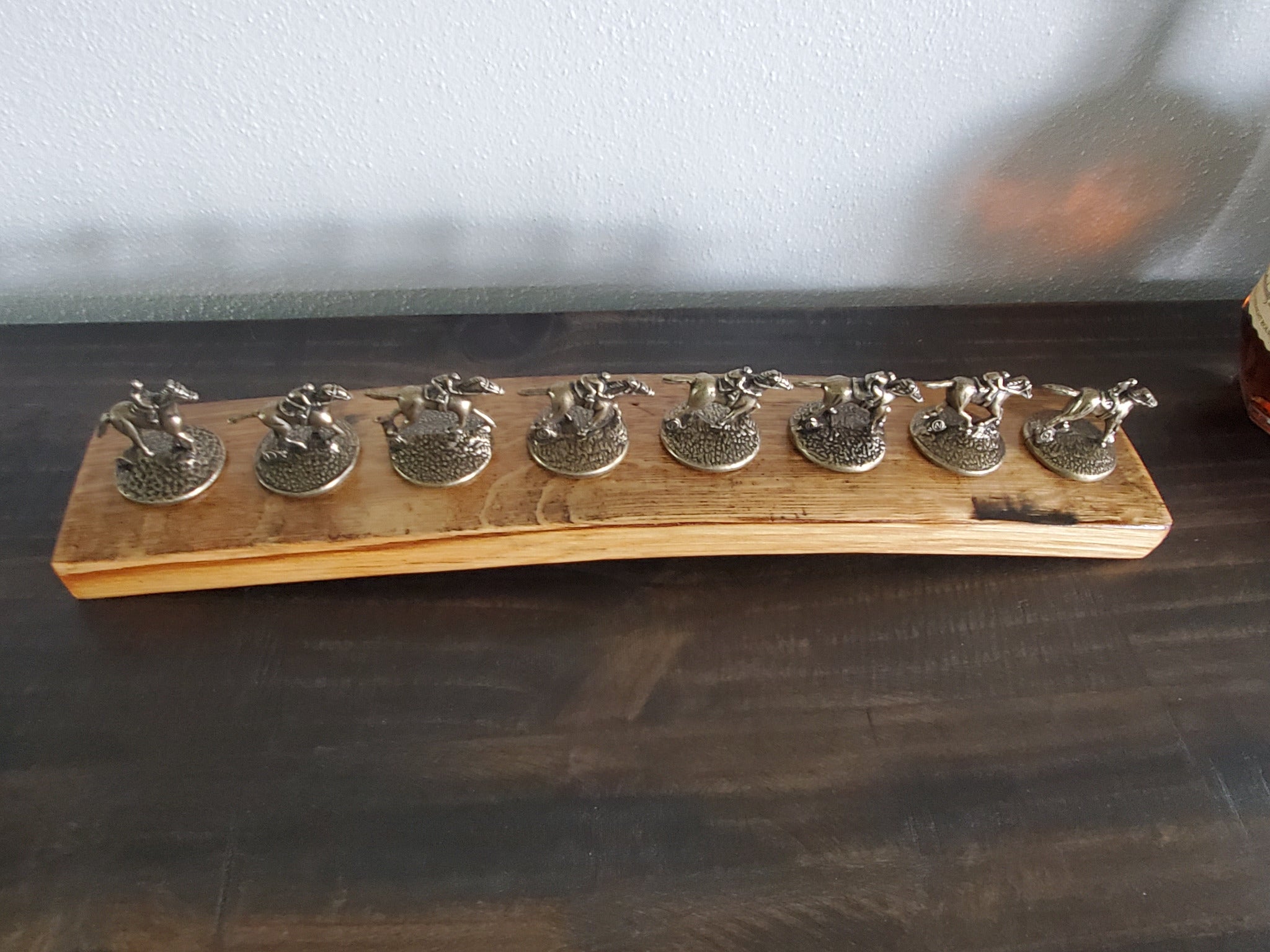 Top view of eight bottle stopper positions on a handcrafted bourbon barrel stave display.
