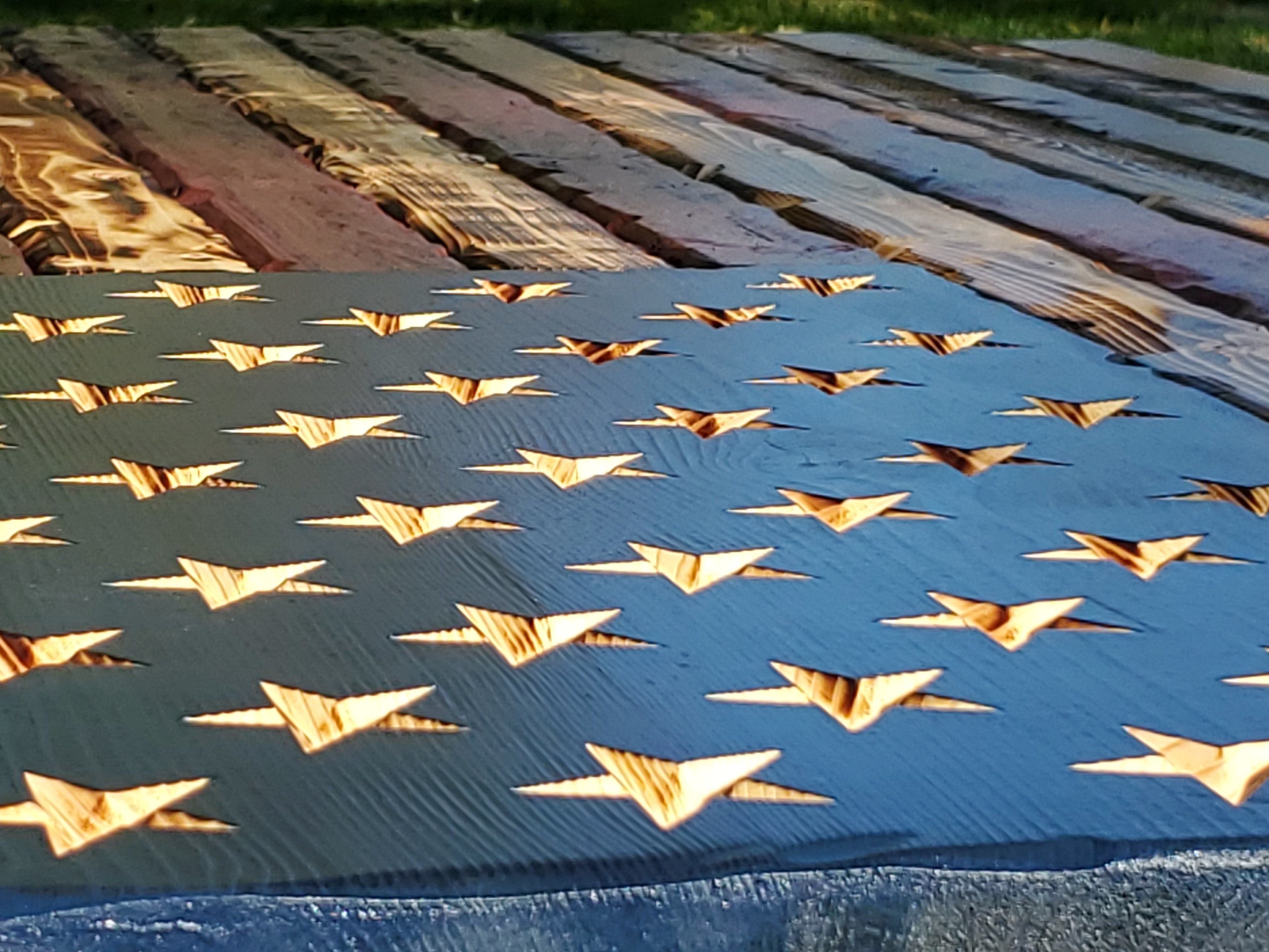 Close-up of carved stars and wood grain on a handcrafted wooden American flag