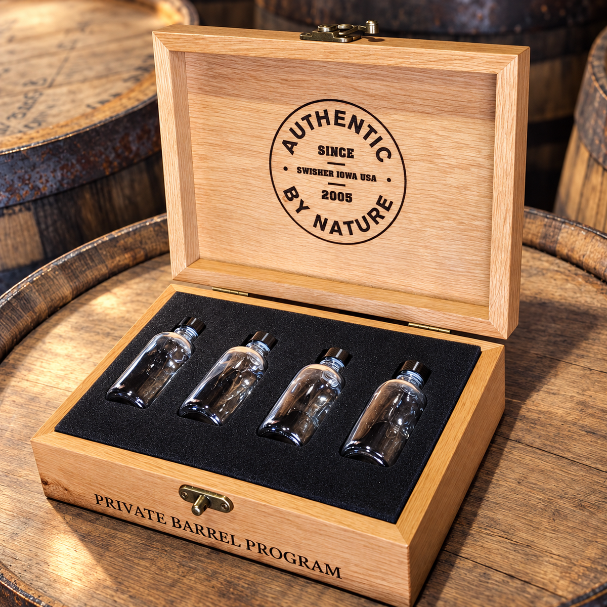 Open custom wooden presentation box with branded lid and four sample bottles held in a fitted insert