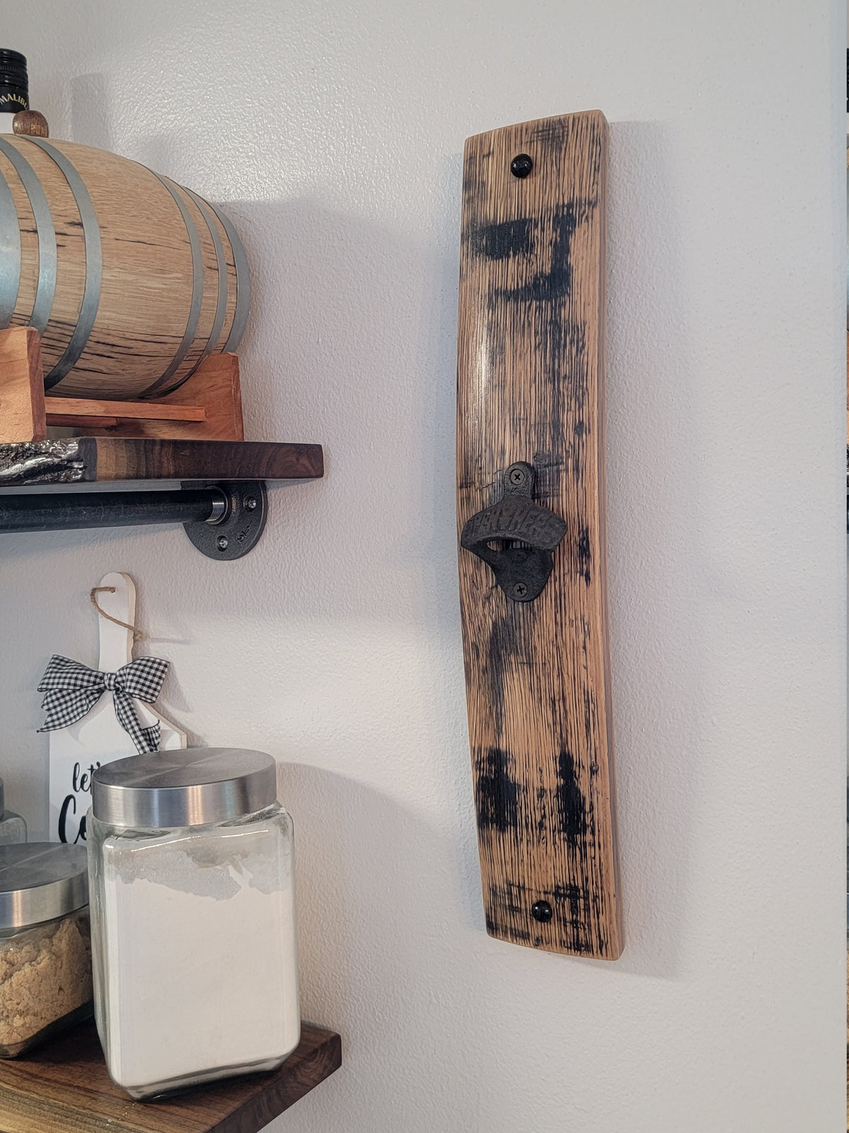 Bottle opener mounted on a vertical whiskey barrel stave