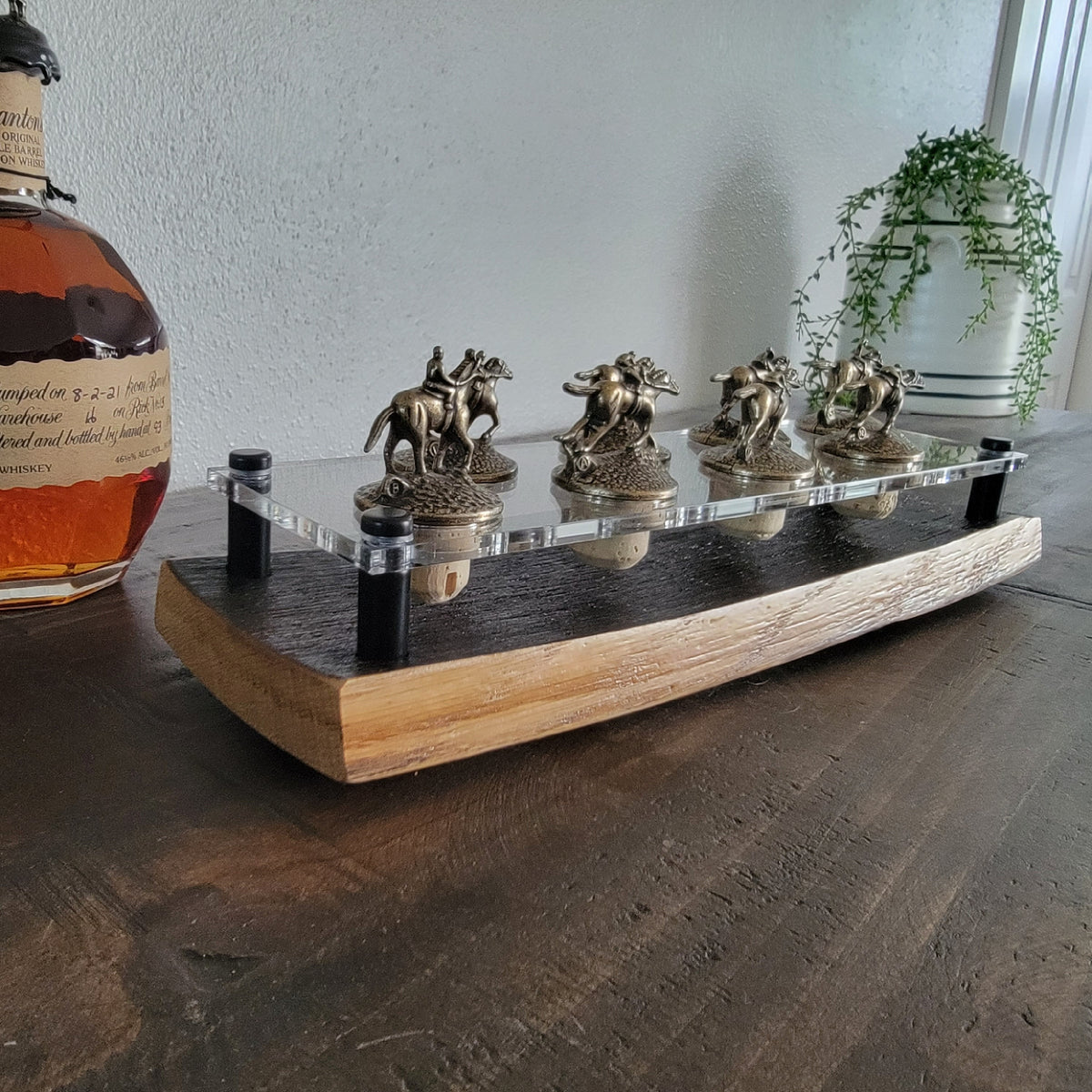 Blanton’s bottle stoppers in two rows on a compact barrel-stave display with a clear acrylic platform
